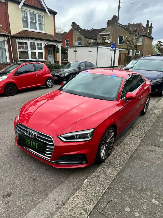 Red Audi A5 Coupe parked on a residential street with blue tape holding its newly fitted windscreen