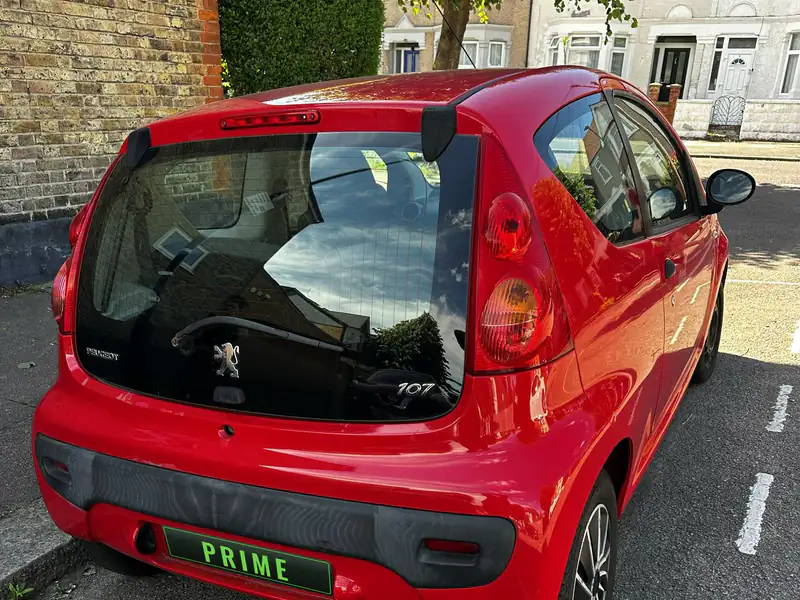 Red Peugeot 107 with the heater lines showing across its rear window