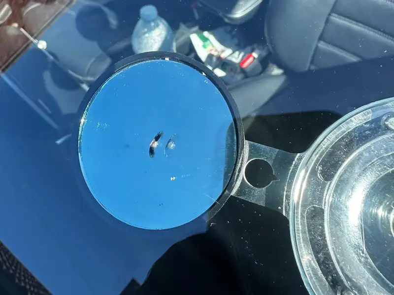 Resin injector fitted over a stone chip on a car windscreen during a repair