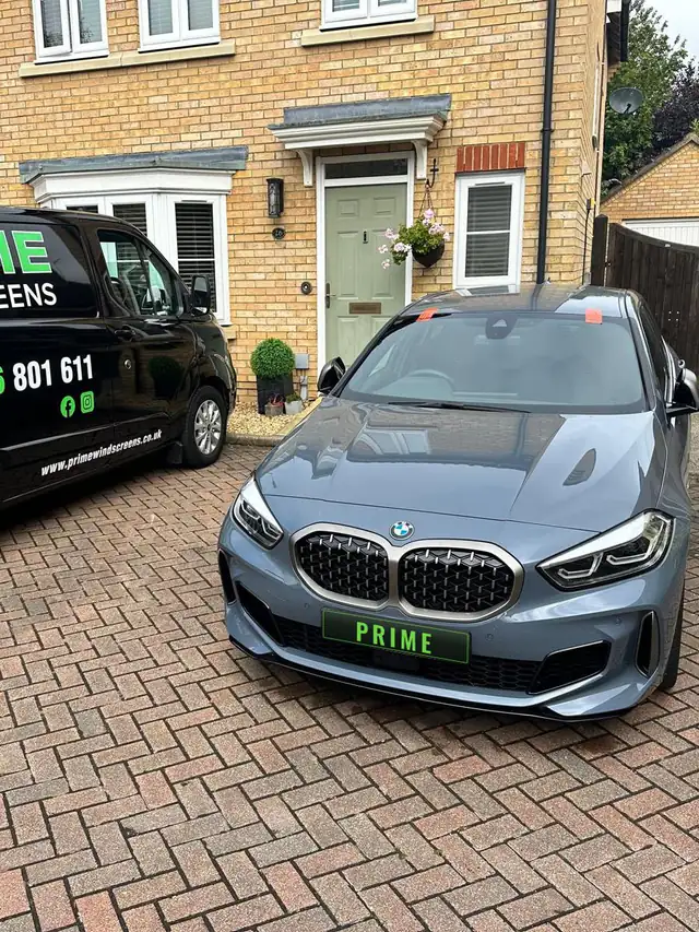 Grey BMW 1 Series on a new build drive in Finchley beside the Prime Windscreens van after a windscreen replacement
