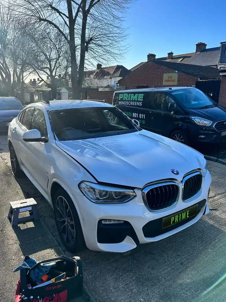 Before: white BMW X4 on a Finchley street with the old windscreen taken out