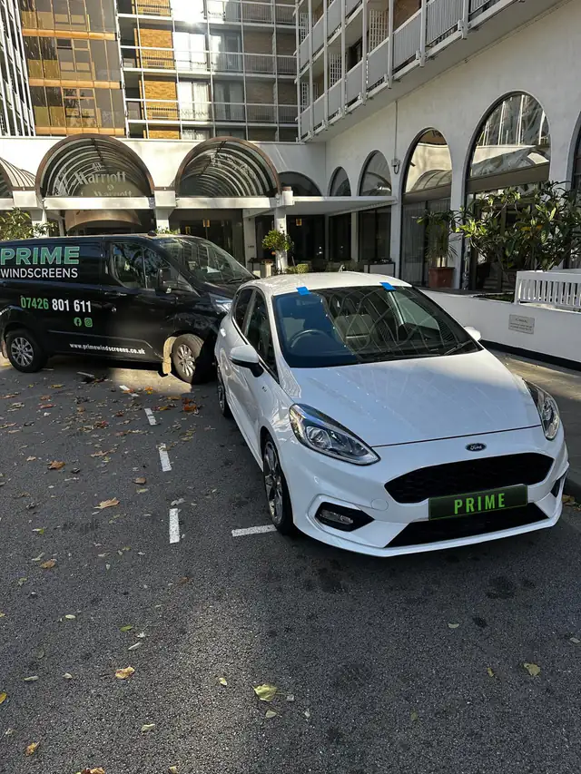 White Ford Fiesta ST Line with a new windscreen in a London hotel car park beside the Prime Windscreens van