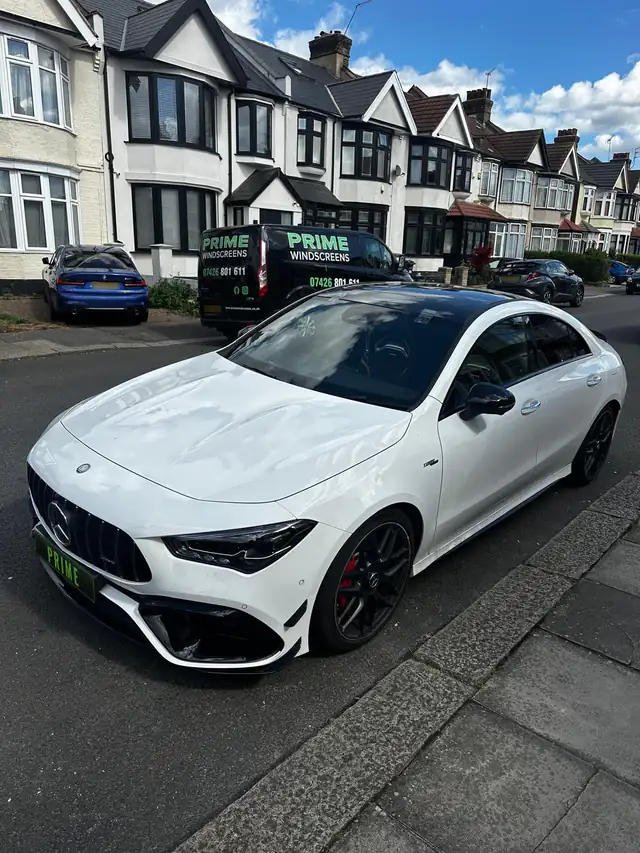 White Mercedes CLA 45 AMG parked on a residential street with a freshly fitted windscreen