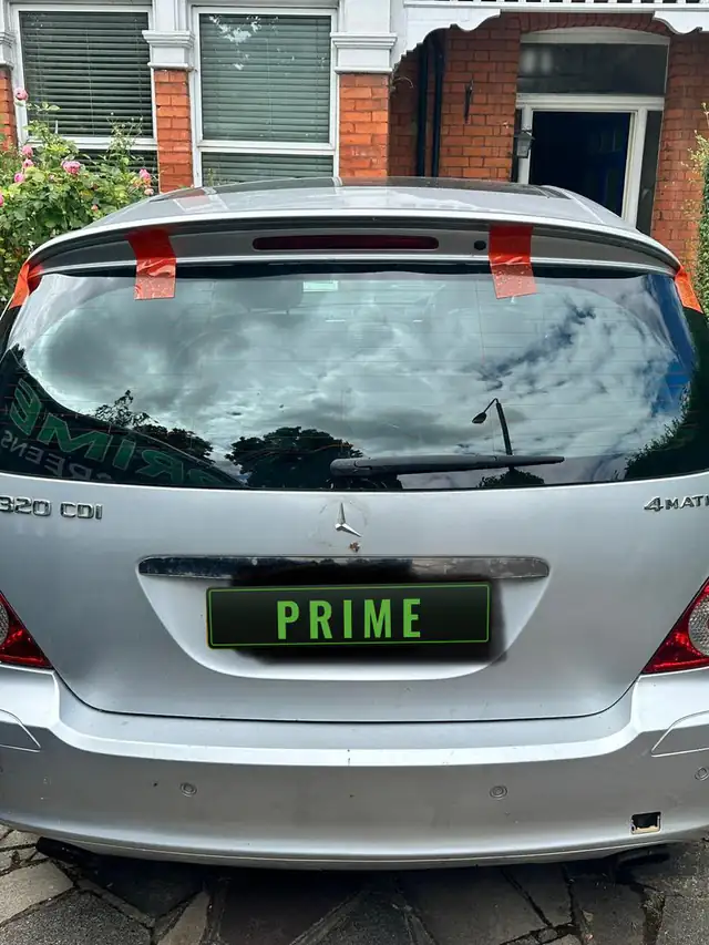 Silver Mercedes R Class on a front drive with red tape holding its new heated tailgate glass