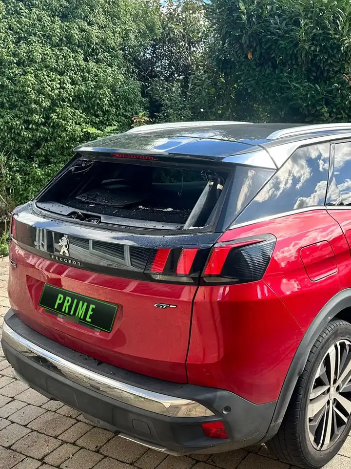Before: red Peugeot 3008 on a Cricklewood drive with the broken rear screen taken out