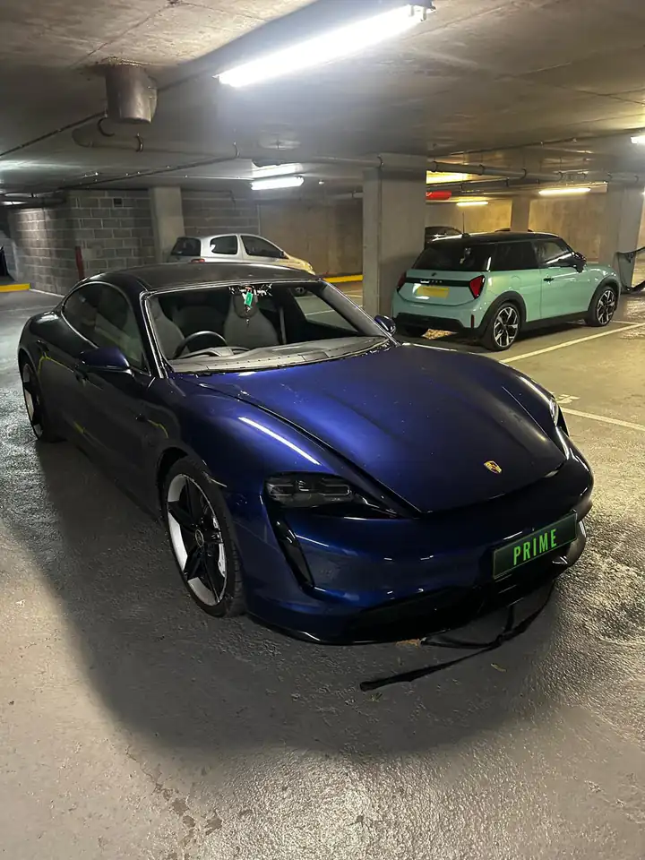 Before: blue Porsche Taycan in an underground car park with the old windscreen taken out