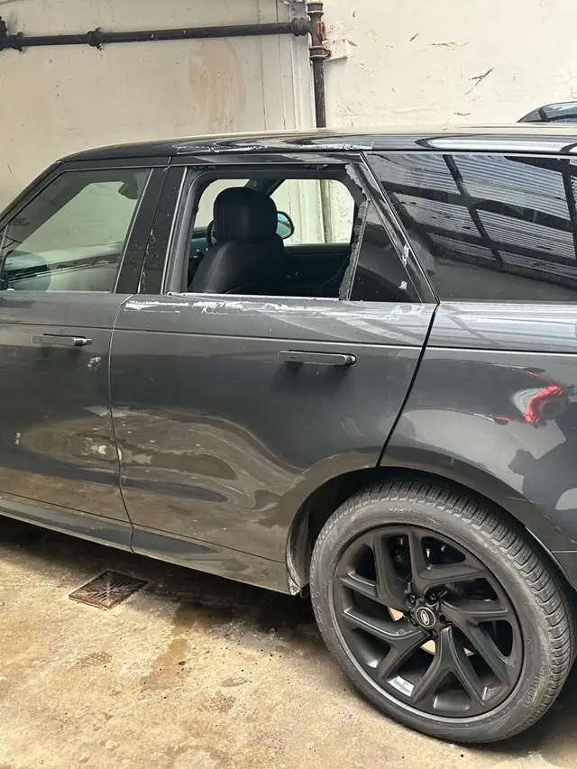 Grey Range Rover Sport in a yard in Enfield with its rear door window smashed